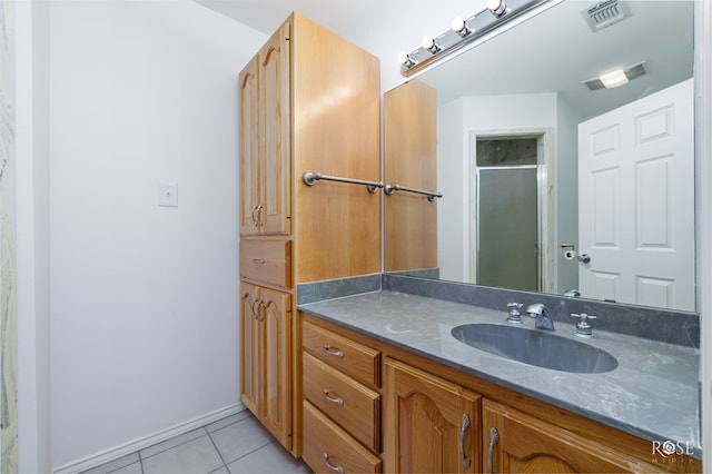 bathroom with tile patterned flooring, vanity, and a shower with shower door