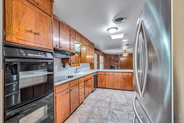2310 W Shandon Ave, Midland, TX 79705 - kitchen with black appliances, light countertops, brown cabinetry, a sink, and under cabinet range hood