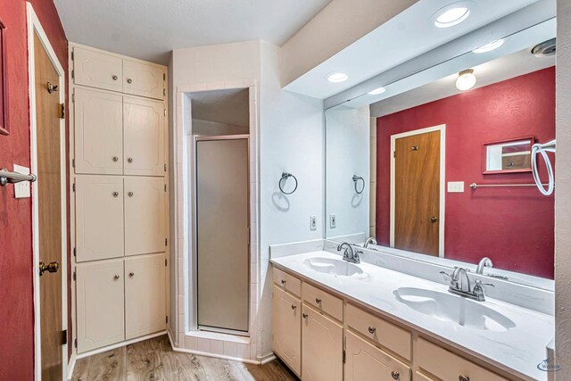 2310 W Shandon Ave, Midland, TX 79705 - full bathroom featuring a shower stall, double vanity, wood finished floors, and a closet
