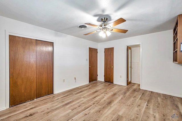 2310 W Shandon Ave, Midland, TX 79705 - unfurnished bedroom featuring multiple closets, wood finished floors, baseboards, and a ceiling fan