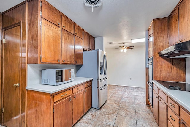 2310 W Shandon Ave, Midland, TX 79705 - kitchen with appliances with stainless steel finishes, brown cabinetry, ceiling fan, under cabinet range hood, and light countertops