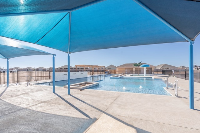 view of swimming pool with pool water feature and a patio