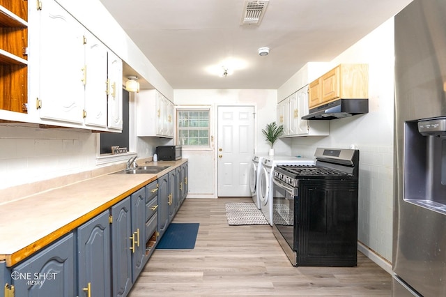 kitchen featuring appliances with stainless steel finishes, sink, washer and dryer, light hardwood / wood-style flooring, and white cabinets