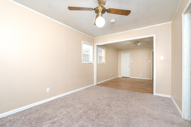 carpeted empty room featuring ceiling fan and crown molding