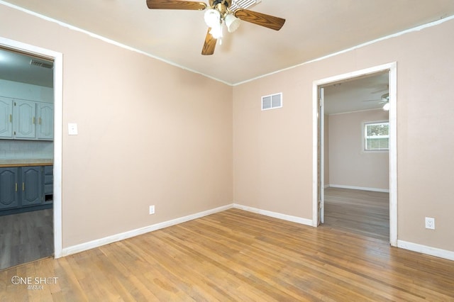 unfurnished room with light hardwood / wood-style floors and crown molding