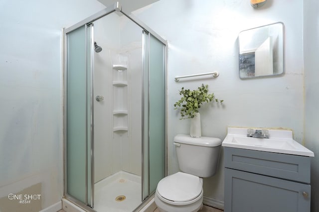 bathroom with an enclosed shower, vanity, and toilet