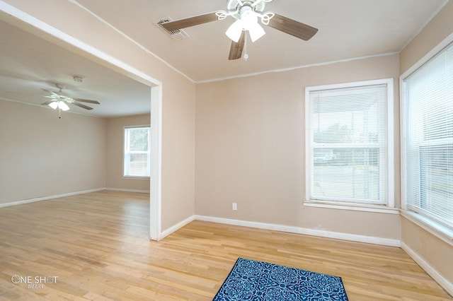 empty room with ceiling fan, ornamental molding, and light wood-type flooring