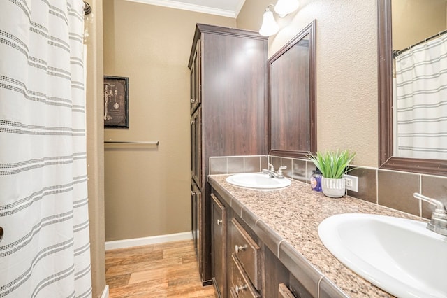 bathroom with decorative backsplash, crown molding, vanity, and wood-type flooring