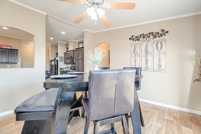 dining area featuring ceiling fan, ornamental molding, and light hardwood / wood-style flooring