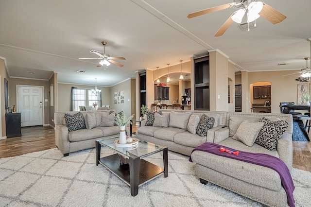 living room featuring hardwood / wood-style floors, crown molding, and a notable chandelier