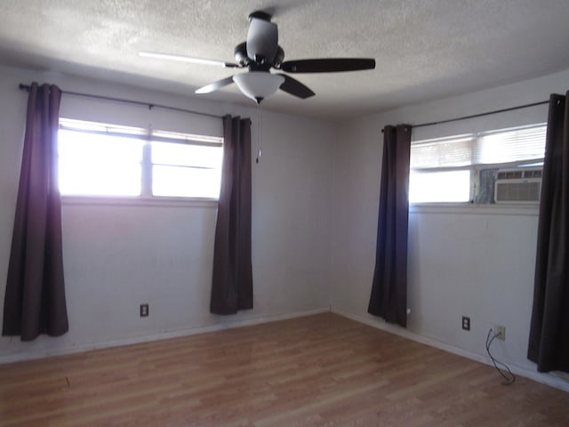 unfurnished room with baseboards, a textured ceiling, a ceiling fan, and wood finished floors