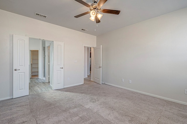 unfurnished bedroom with light carpet, a closet, and ceiling fan