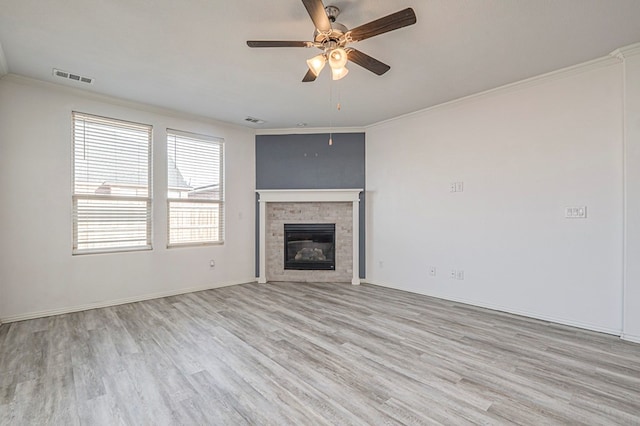 unfurnished living room with ceiling fan, crown molding, and light wood-type flooring