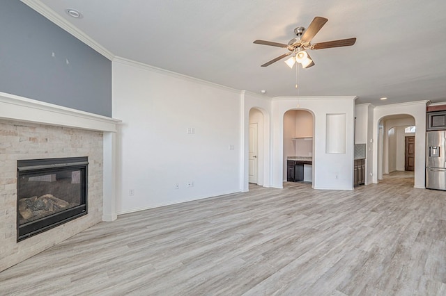 unfurnished living room featuring light wood-type flooring, ceiling fan, and crown molding