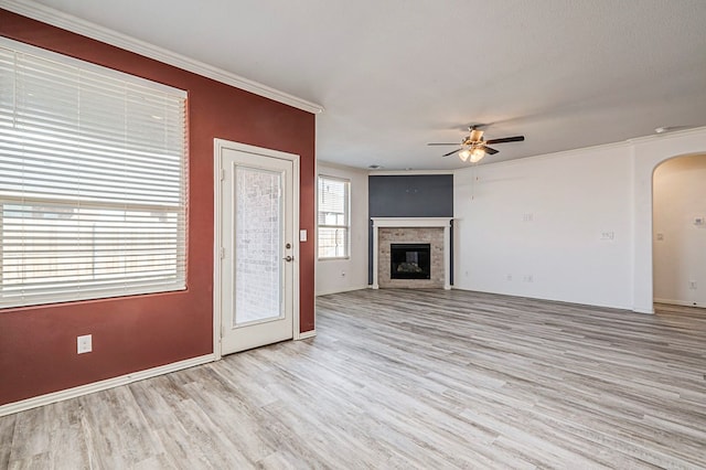 unfurnished living room featuring ceiling fan, crown molding, and light wood-type flooring