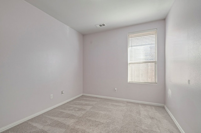 spare room featuring light colored carpet