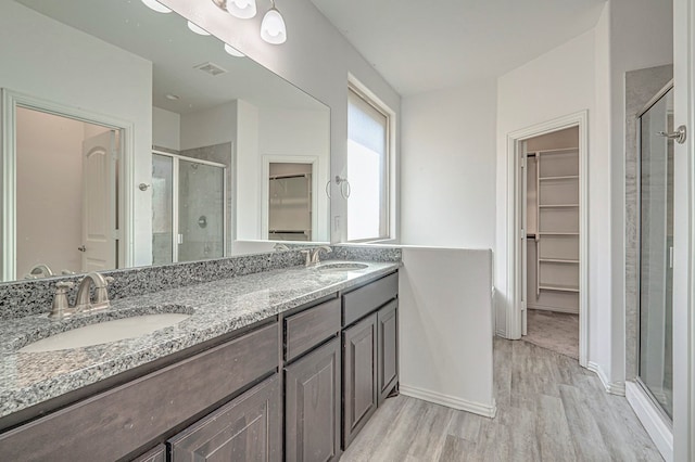 bathroom featuring hardwood / wood-style floors, walk in shower, and vanity