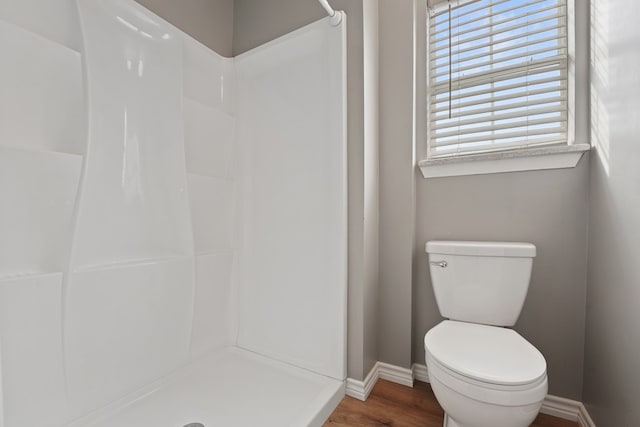 bathroom with hardwood / wood-style floors, toilet, and walk in shower