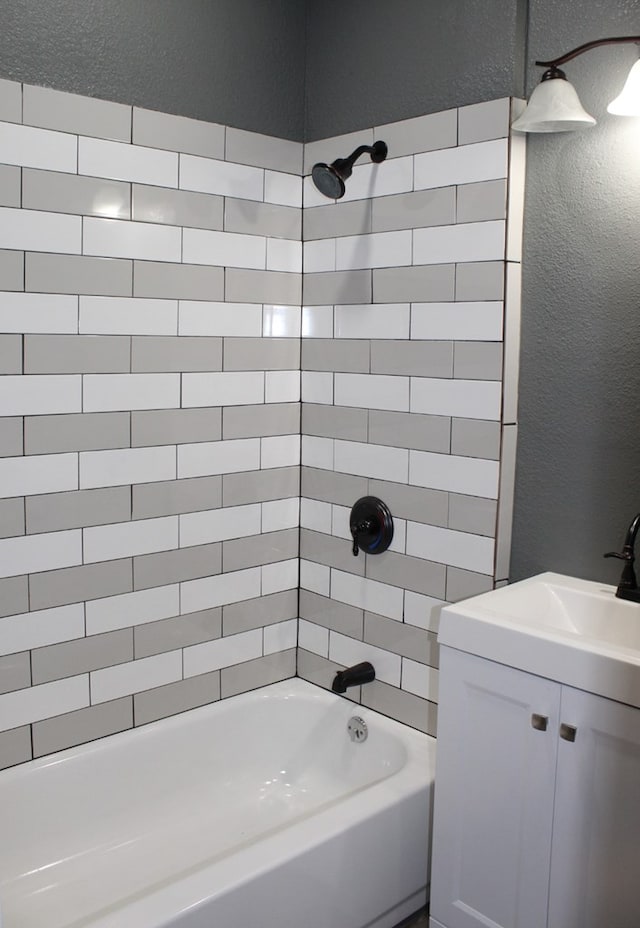 bathroom with vanity and tiled shower / bath