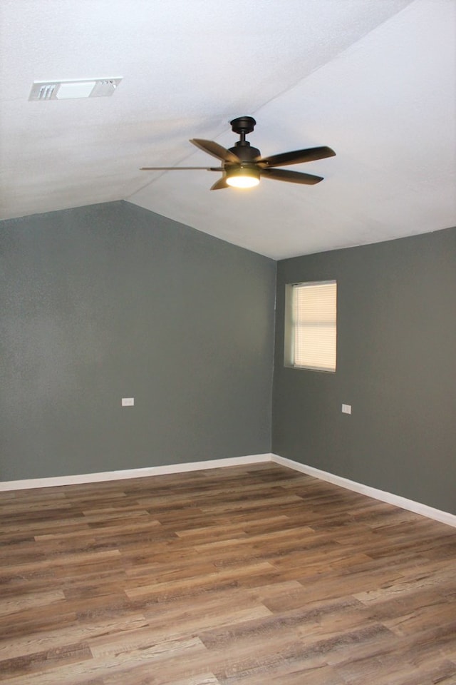 empty room featuring ceiling fan, wood-type flooring, and vaulted ceiling