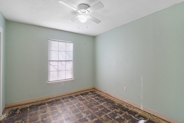 unfurnished room with ceiling fan and a textured ceiling