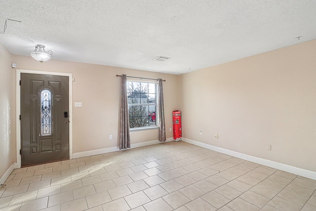 tiled foyer entrance featuring a textured ceiling