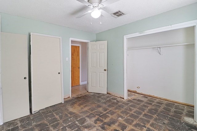 unfurnished bedroom featuring a textured ceiling, ceiling fan, and a closet