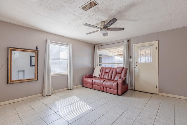 1304 Lynn Ave, Midland, TX 79705 - living area with plenty of natural light, a textured ceiling, light tile patterned floors, a ceiling fan, and baseboards