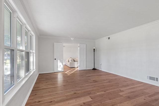 empty room with crown molding and hardwood / wood-style flooring