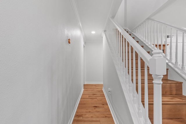 stairs featuring hardwood / wood-style flooring and ornamental molding