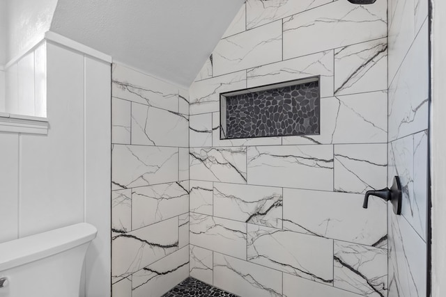 bathroom featuring toilet and tiled shower