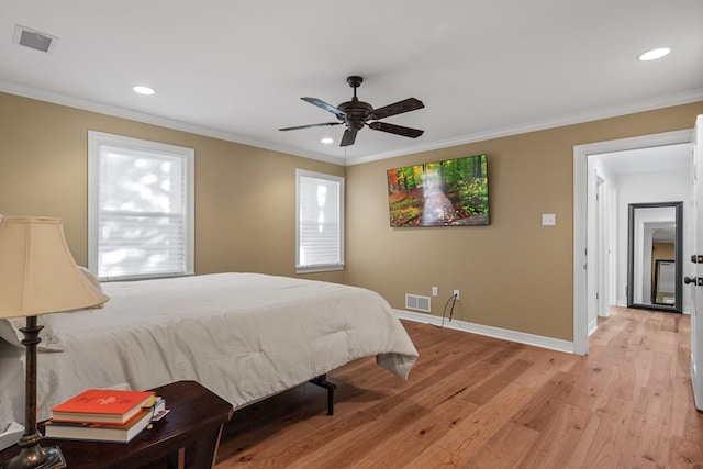 bedroom featuring multiple windows, ceiling fan, crown molding, and light wood-type flooring