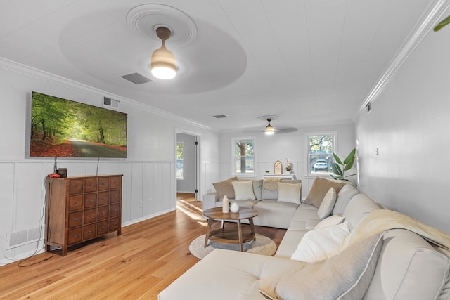 living room with light hardwood / wood-style floors, ceiling fan, and crown molding