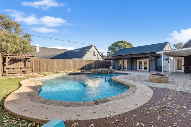 view of pool with pool water feature, a patio area, an outbuilding, and an in ground hot tub