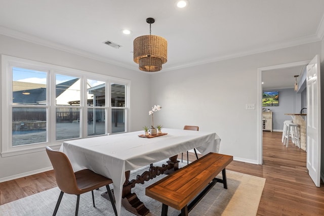 dining area with dark hardwood / wood-style floors and ornamental molding