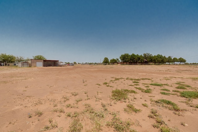 2429 S County Rd 1120, Midland, TX 79706 - view of yard featuring a garage, an outbuilding, a view of rural / pastoral area, and an outdoor structure