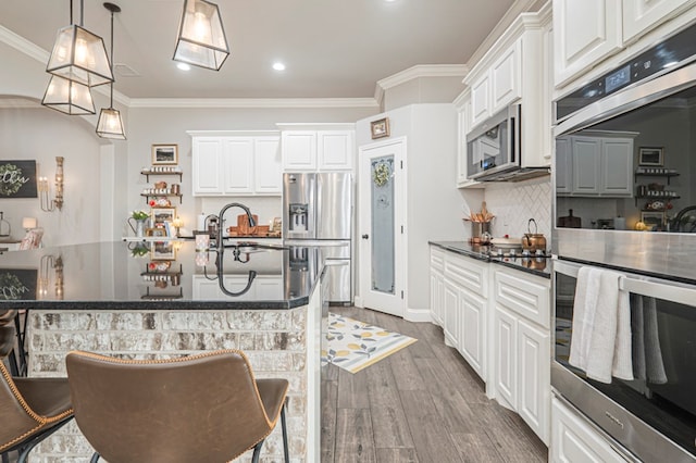 2900 S County Rd 1092, Midland, TX 79706 - kitchen featuring ornamental molding, appliances with stainless steel finishes, wood finished floors, a sink, and dark countertops