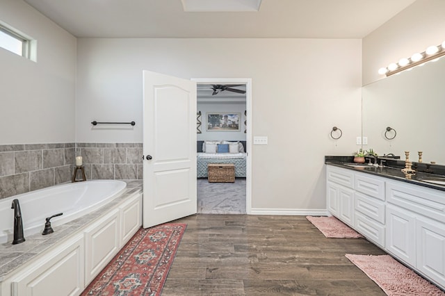 2900 S County Rd 1092, Midland, TX 79706 - ensuite bathroom featuring a sink, double vanity, connected bathroom, a garden tub, and wood finished floors