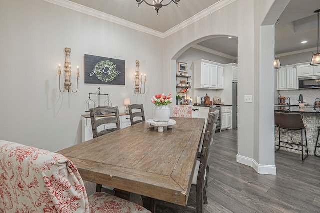 2900 S County Rd 1092, Midland, TX 79706 - dining area with a notable chandelier, dark wood-style flooring, baseboards, ornamental molding, and arched walkways