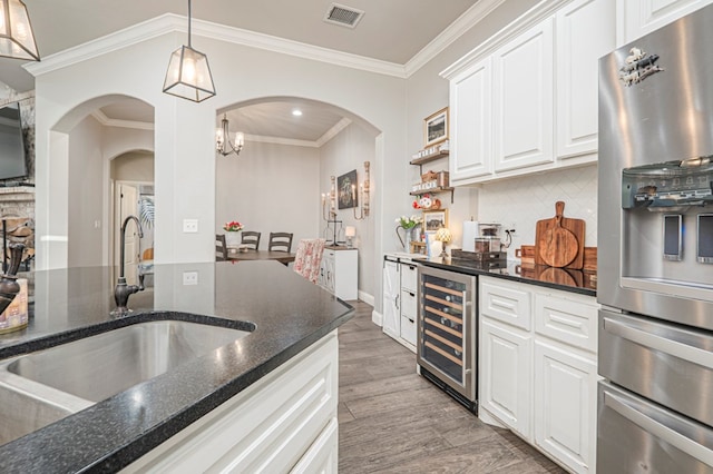 2900 S County Rd 1092, Midland, TX 79706 - kitchen featuring stainless steel fridge with ice dispenser, visible vents, arched walkways, a sink, and wine cooler