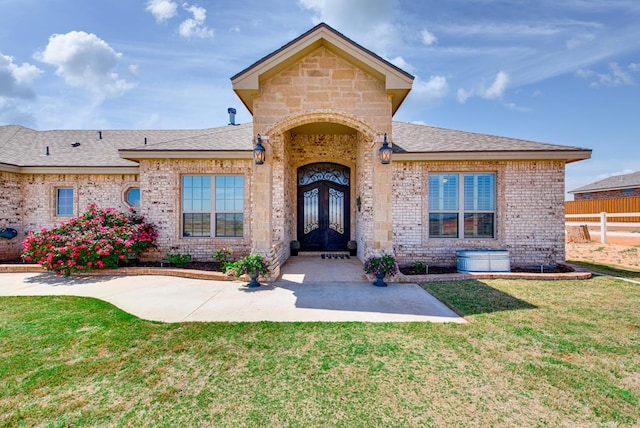 2900 S County Rd 1092, Midland, TX 79706 - view of front of property with roof with shingles, a front yard, fence, brick siding, and french doors