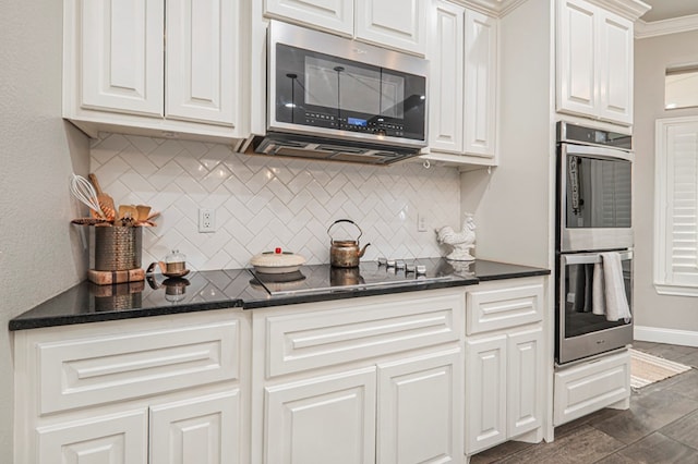 2900 S County Rd 1092, Midland, TX 79706 - kitchen with white cabinetry, backsplash, baseboards, and appliances with stainless steel finishes