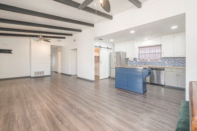 kitchen with white cabinetry, a barn door, ceiling fan, and appliances with stainless steel finishes