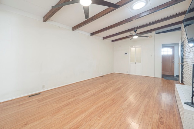 empty room with beam ceiling, light hardwood / wood-style flooring, and ceiling fan