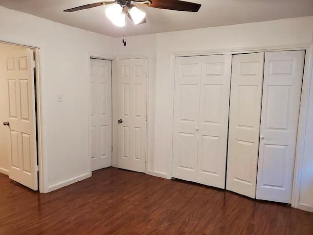 unfurnished bedroom featuring multiple closets, ceiling fan, and dark hardwood / wood-style floors