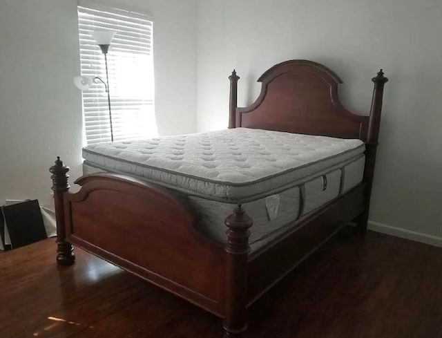 bedroom with dark hardwood / wood-style flooring