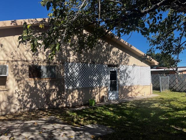 rear view of property featuring a lawn