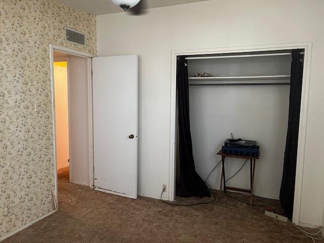 unfurnished bedroom featuring carpet flooring and a closet