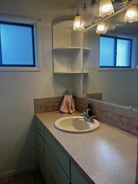 bathroom featuring vanity, a chandelier, and backsplash