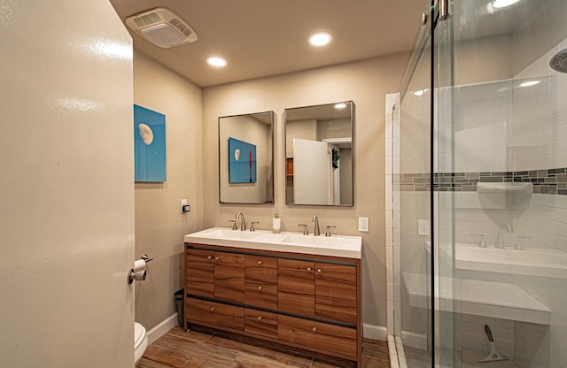 bathroom featuring vanity, toilet, and an enclosed shower